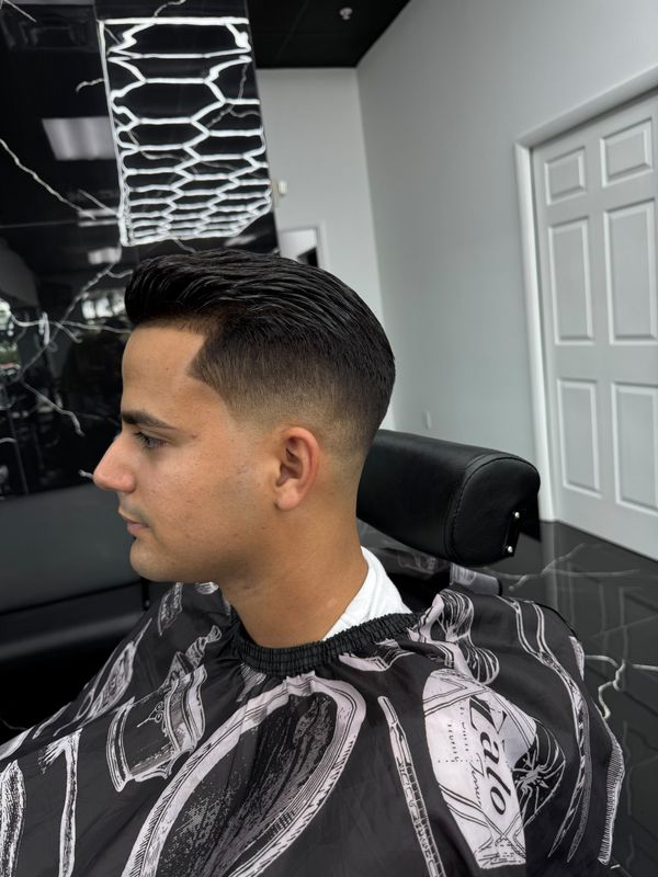 Slicked-back cut with a low fade, profile